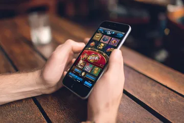 A cheerful woman in traditional clothing using her smartphone during a festive moment, showing how easily the 456BD app fits into everyday life.